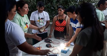 Energia solar esquenta debate internacional no Sertão da Paraíba DESCRIÇÃO: Seis pessoas aparecem em torno de mesa onde estão sendo montadas pequenas placas de energia fotovotaica durante o curso. Uma lâmpada está acesa com a energia gerada pelo sol. Foto: Inês Campelo/MZ Conteúdo
