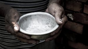 Mãos de uma mulher negra segura prato branco sujo e vazio