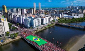 Imagem aérea da ponte Duarte Coelho com uma multidão de eleitores de Lula e uma bandeira do Brasil enorme