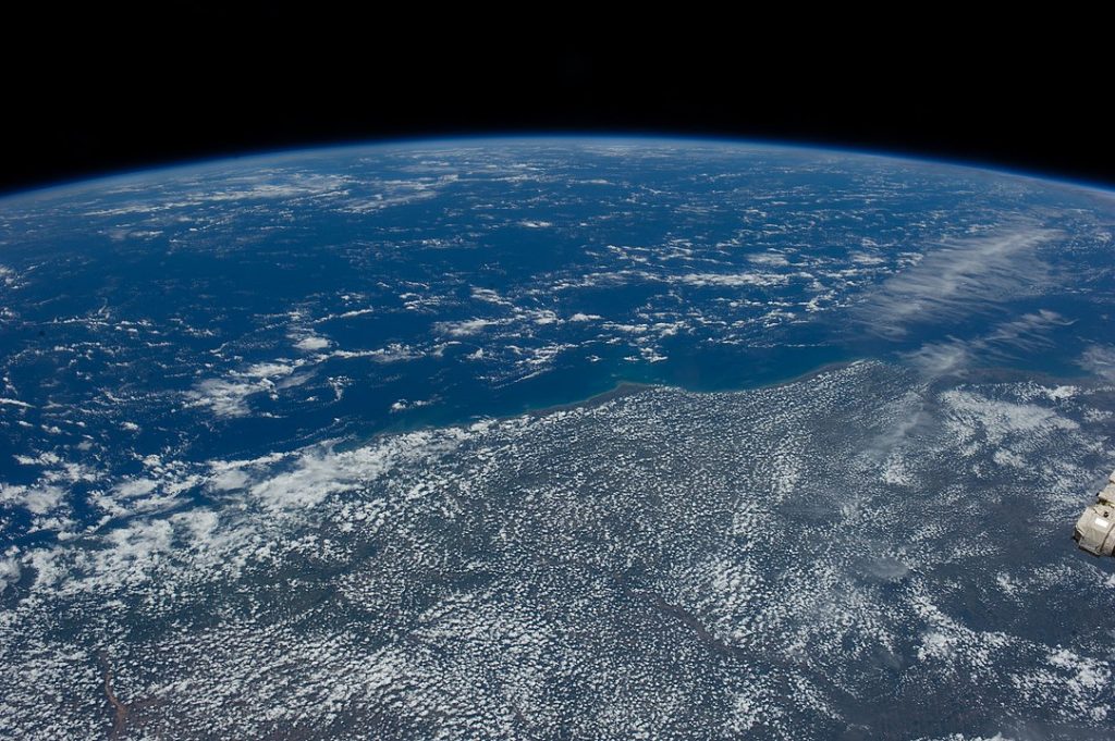 Parte do litoral brasileiro e do Oceano Atlântico, com poucas nuvens, vistos do espaço.