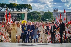 Lula sobe a rampa do Palácio do Planalto de mãos dadas com pessoas comuns que representam a população brasileira