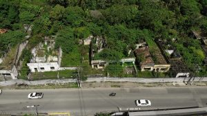 Vista aérea de bairro evacuado em Maceió, com algumas casas vazias e dois bairros passando em avenida
