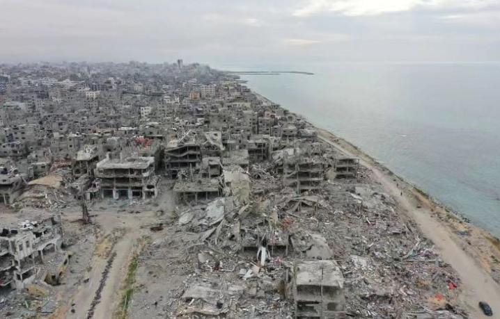 Imagem aérea de escombros de uma cidade à beira-mar completamente destruída e vazia