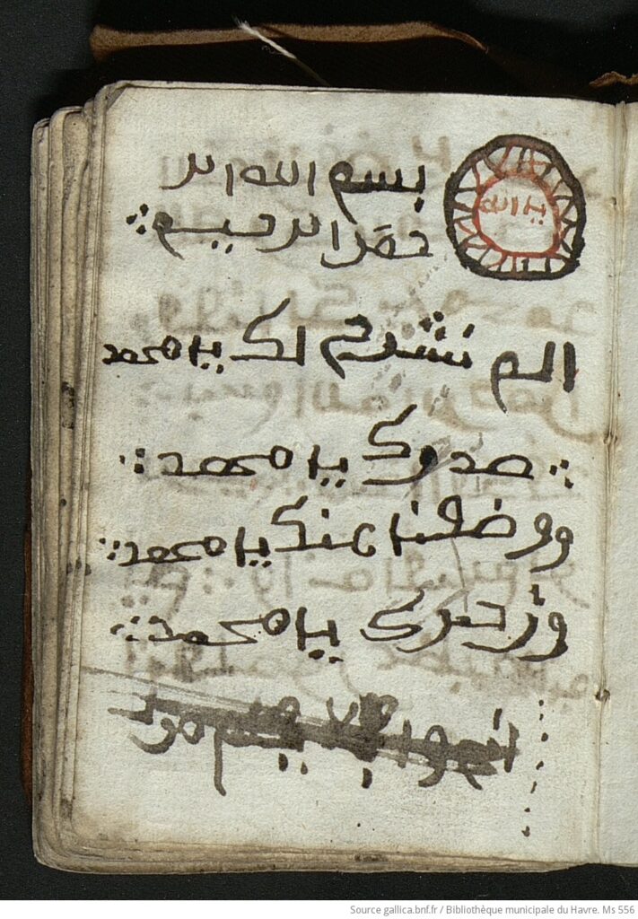 Fragmento de papel amarelado,. envelhecido, com inscrições em árabe que dizem Em nome de Allah, o Clemente, o Misericordioso Não abrimos para você o seu peito E não aliviamos de você o seu fardo Que pesou sobre suas costas E elevamos a sua lembrança. Este é o início da Surata Ash-Sharh (A Abertura) do Alcorão.