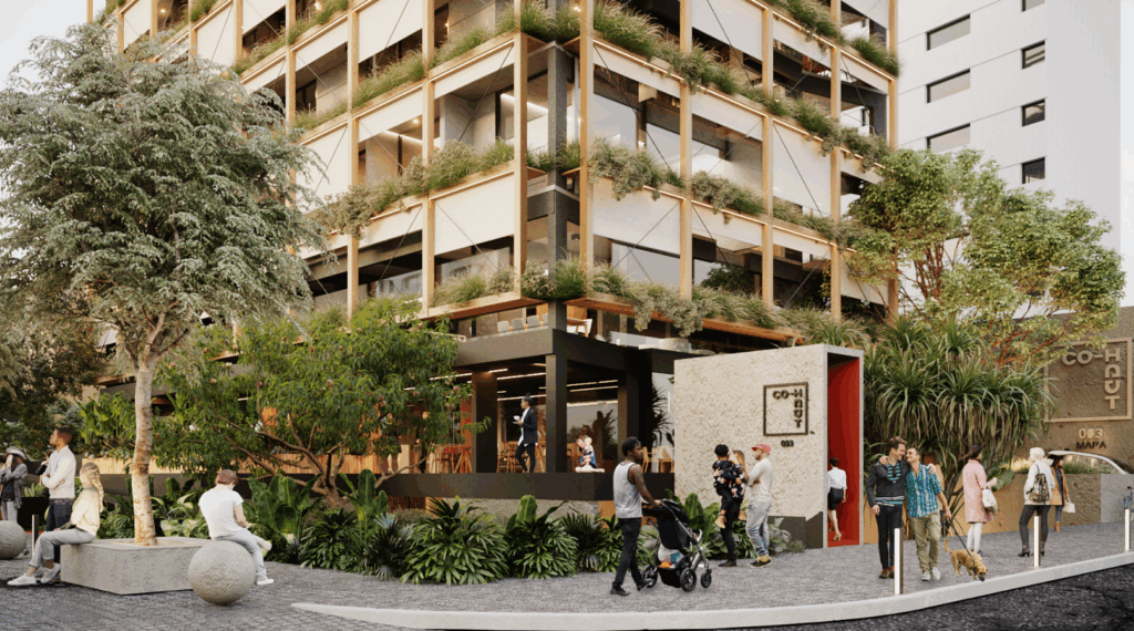 A imagem mostra a fachada de um edifício moderno, com varandas cheias de plantas e estrutura em madeira clara. No térreo, há um espaço envidraçado com pessoas sentadas, sugerindo um café ou área de convivência. A calçada é larga e arborizada, com bancos, árvores e vegetação abundante. Diversas pessoas estão presentes: algumas passeiam, outras conversam ou caminham com crianças e cães. O ambiente transmite uma sensação de urbanismo acolhedor e sustentável. Na entrada, uma placa identifica o local como “CO-HAUT 003”. O cenário é vibrante, acessível e voltado à comunidade.