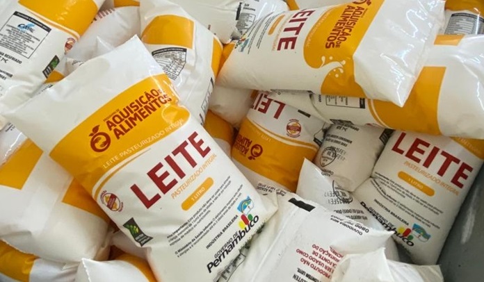 O ChatGPT disse: A imagem mostra vários pacotes de leite empilhados, todos embalados em sacos plásticos brancos com detalhes em amarelo e vermelho. As embalagens trazem impressa a marca do programa Aquisição de Alimentos, do Governo de Pernambuco, com destaque para a palavra LEITE em letras grandes e vermelhas. Abaixo, está escrito pasteurizado integral. Também é visível o logotipo do governo estadual com a frase Governo de Pernambuco. Esses pacotes são distribuídos por programas sociais voltados ao combate à fome e à desnutrição.