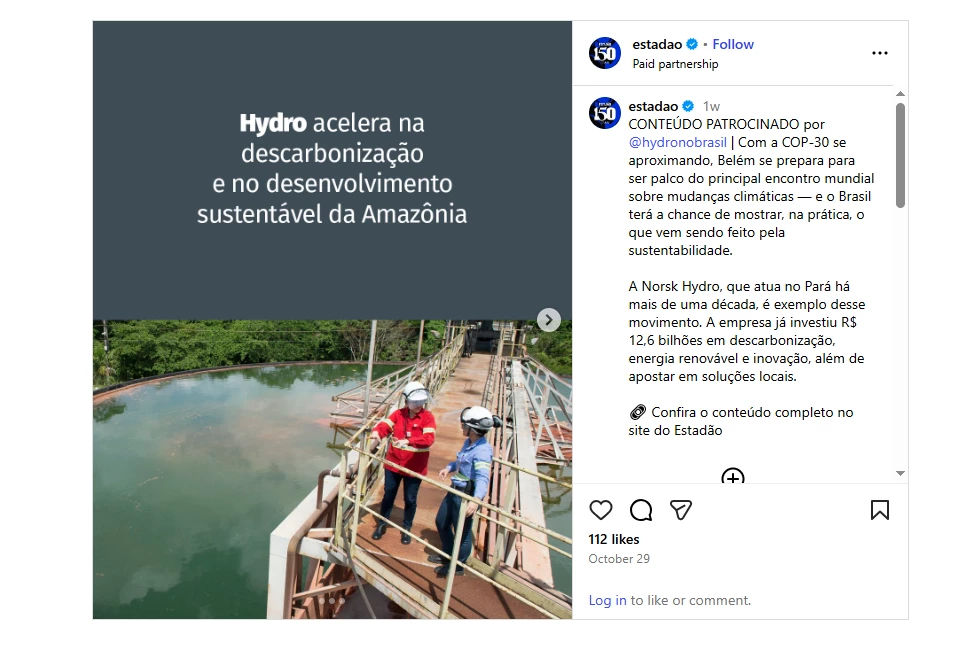 A imagem mostra um conteúdo patrocinado publicado no Instagram pelo perfil @hydronobrasil em parceria com o jornal Estadão, destacando a atuação da empresa Hydro na Amazônia. À esquerda, sobre um fundo escuro, há uma frase em destaque que diz: “Hydro acelera na descarbonização e no desenvolvimento sustentável da Amazônia”. À direita, vê-se uma fotografia de três pessoas usando capacetes e equipamentos de segurança, em pé sobre uma plataforma metálica acima de um corpo de água, sugerindo um ambiente industrial. A legenda informa que, com a aproximação da COP30 — conferência global sobre mudanças climáticas — a cidade de Belém se prepara para sediar o evento, e o Brasil terá a oportunidade de mostrar seus avanços. A empresa Norsk Hydro, que atua no Pará há mais de dez anos, é apresentada como exemplo de compromisso com inovação e sustentabilidade, tendo investido R$ 12,6 bilhões nos últimos cinco anos.