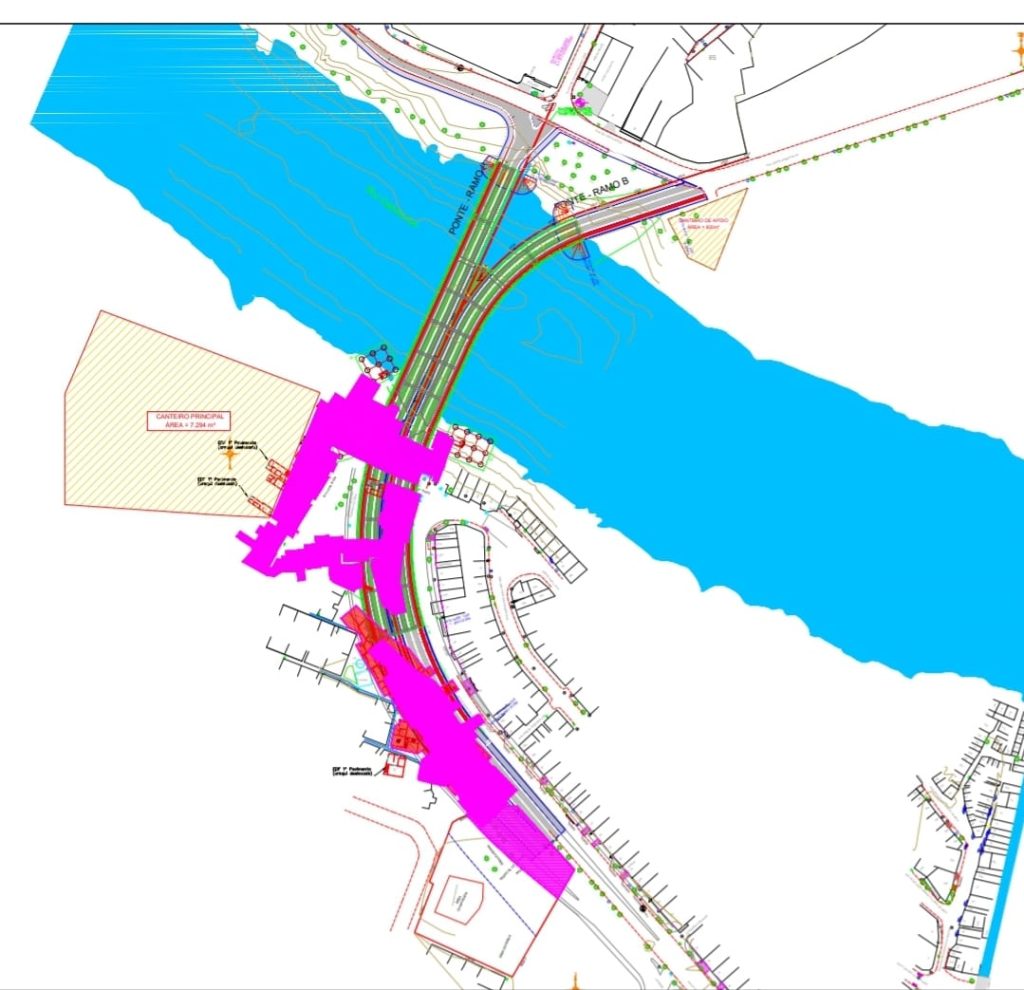 A imagem mostra um mapa técnico colorido, possivelmente de um projeto de engenharia urbana. No centro, há um rio largo em azul que divide o mapa horizontalmente. Sobre ele, passa uma ponte representada por linhas verdes e vermelhas paralelas, ligando as duas margens. Em torno da ponte e nas vias próximas, há várias áreas destacadas em rosa e roxo, que indicam zonas de desapropriação ou intervenção. As ruas ao redor estão desenhadas com linhas finas, mostrando o traçado do bairro. À esquerda, um retângulo listrado em vermelho marca uma “área a ser desapropriada”, identificada como “canteiro de obras”. A imagem combina elementos urbanos, topográficos e de infraestrutura para mostrar o impacto territorial do projeto.