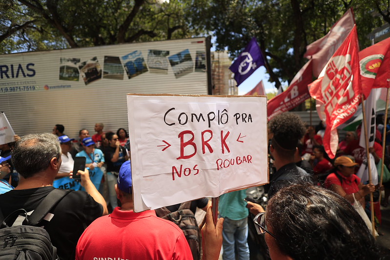Foto de um ato público em Recife contra a privatização da Compesa, com manifestantes reunidos em frente à Assembleia Legislativa de Pernambuco (ALEPE) no bairro da Boa Vista, área central da cidade.