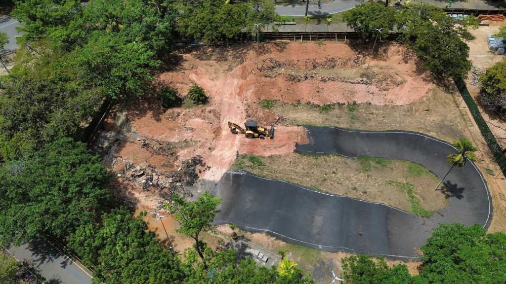 Vista aérea da área da pista de bicicross do Parque da Jaqueira demolida, com trator sobre o terreno de barro exposto