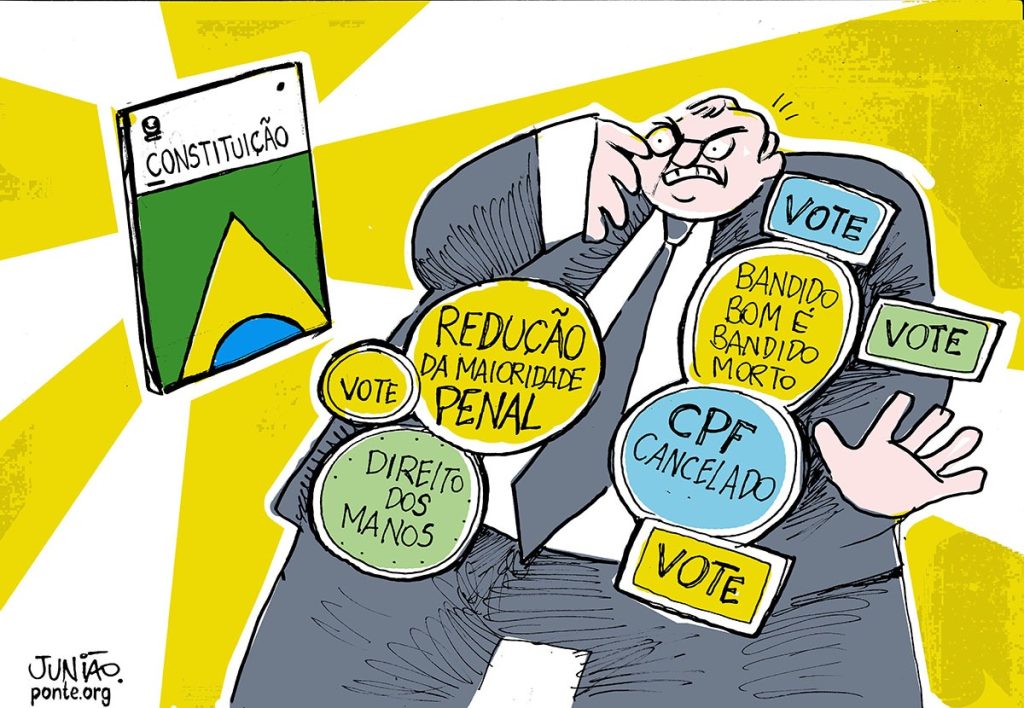 A ilustração mostra uma charge política colorida em que um homem de terno e expressão irritada tenta se proteger de uma Constituição brasileira que brilha intensamente ao fundo. Em volta dele, há vários círculos e placas com frases como “Redução da maioridade penal”, “Bandido bom é bandido morto”, “CPF cancelado” e “Direito dos manos”, todas acompanhadas da palavra “Vote”. A imagem critica discursos populistas e punitivistas que se chocam com os princípios constitucionais e os direitos humanos.